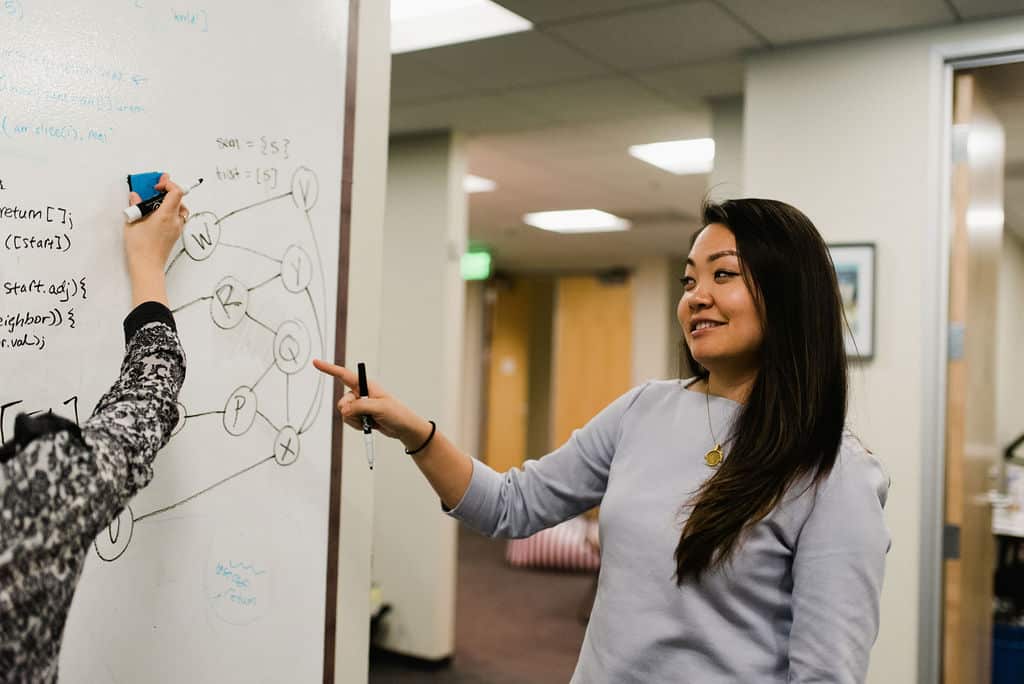 Rithm student displaying her problem-solving on a whiteboard